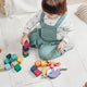 A young child playing safely with colourful non-toxic wooden toys at home